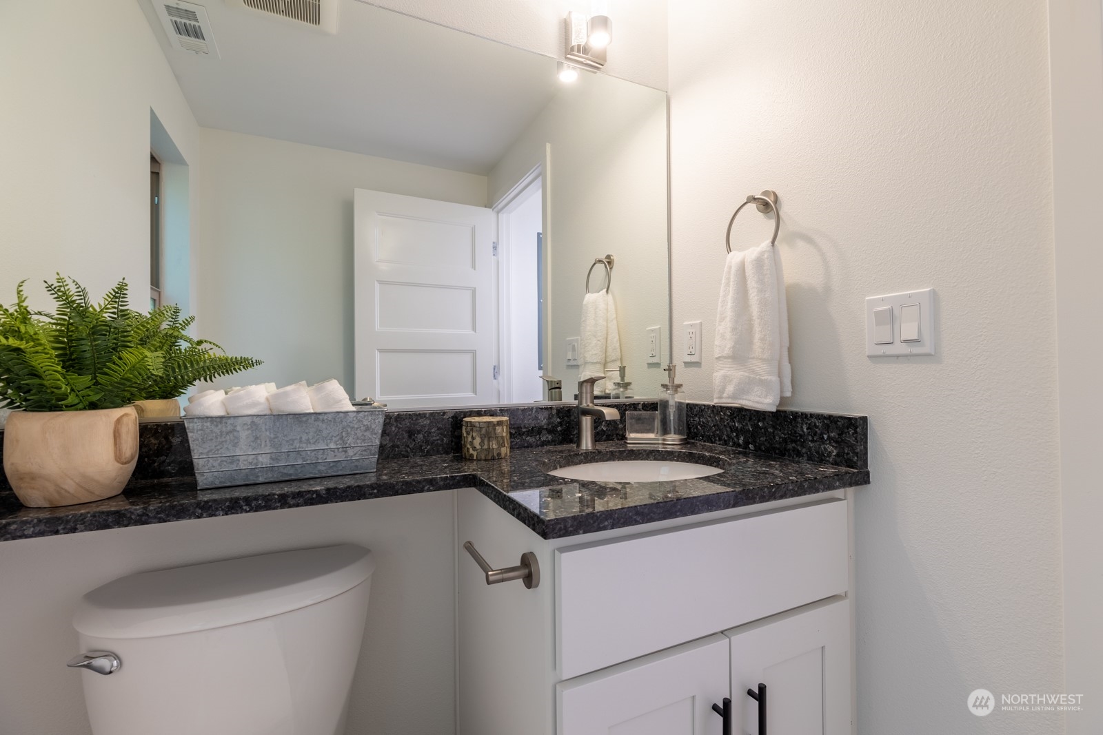 4901 Cleveland Street Port Townsend, WA 98368 - Photo 21 of 39 a bathroom with a granite countertop sink a toilet and a mirror