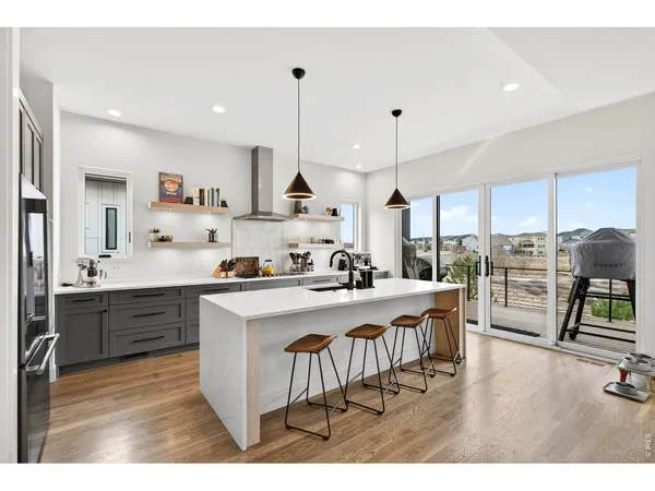 a kitchen with kitchen island a stove a table and chairs
