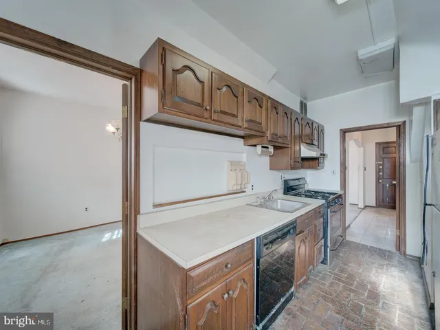 a view of a kitchen with refrigerator and a stove