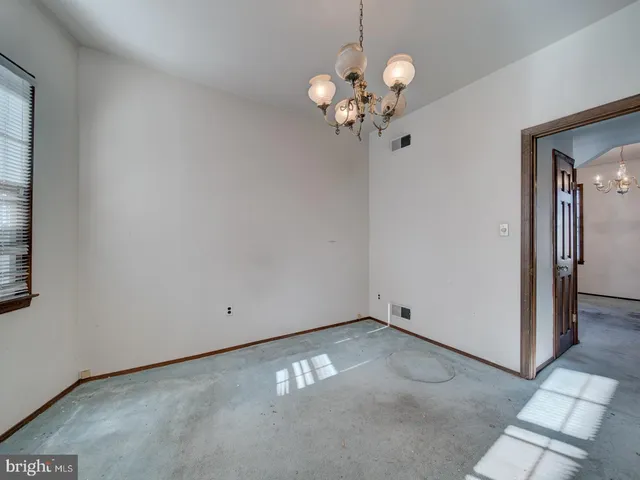 a view of a hallway with bathroom and wooden floor