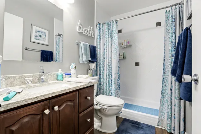 a bathroom with a granite countertop sink toilet and shower
