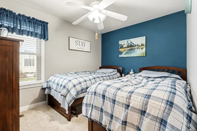 a bedroom with two beds and a chandelier
