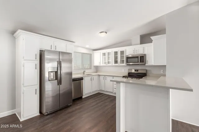 a kitchen with stainless steel appliances a refrigerator sink and microwave