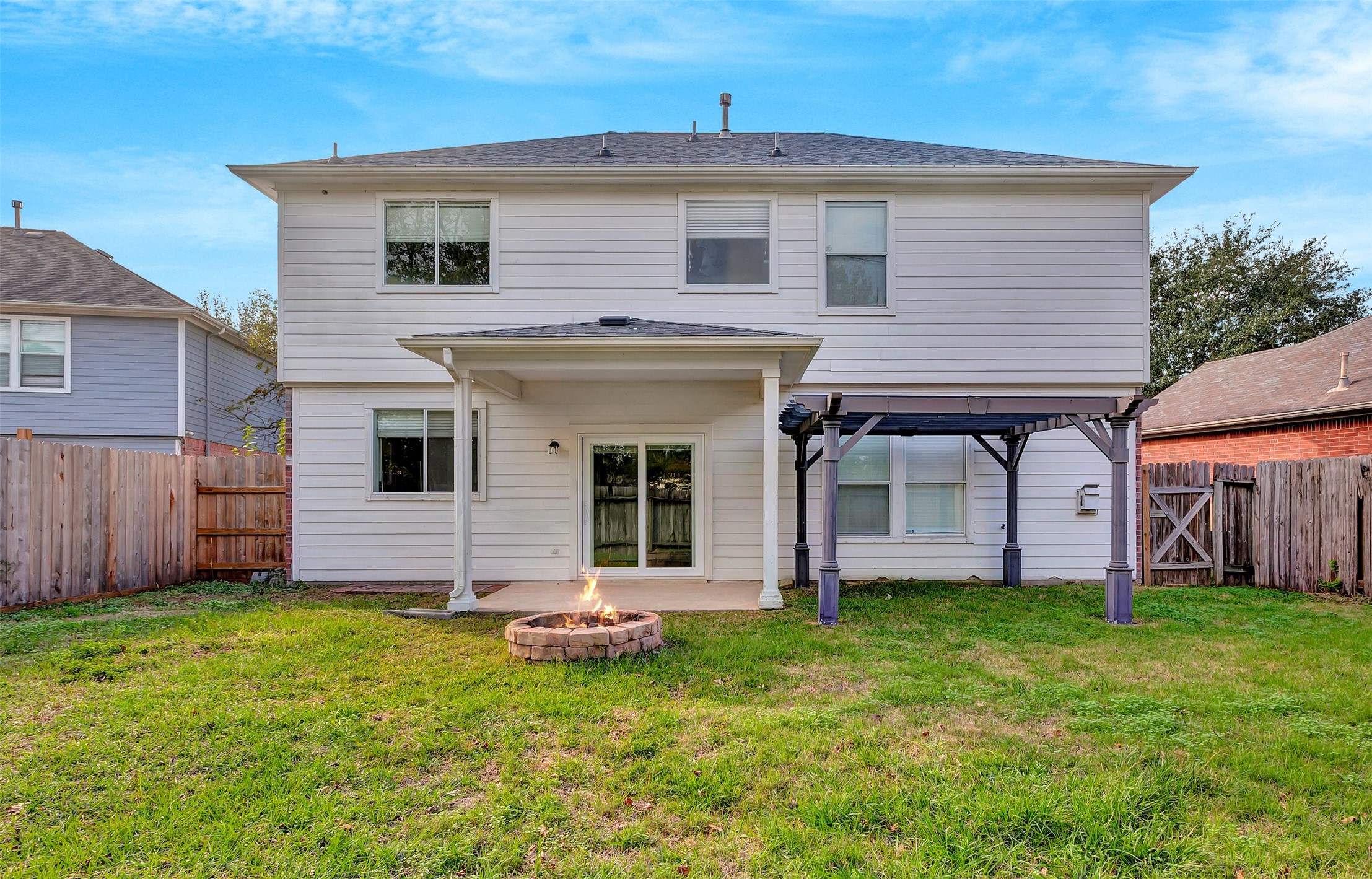 1007 Addison Park Lane Spring, TX 77373 - Photo 23 of 24 Experience outdoor bliss in this spacious backyard oasis, perfect for relaxation and entertaining under a charming pergola next to a cozy fire pit.