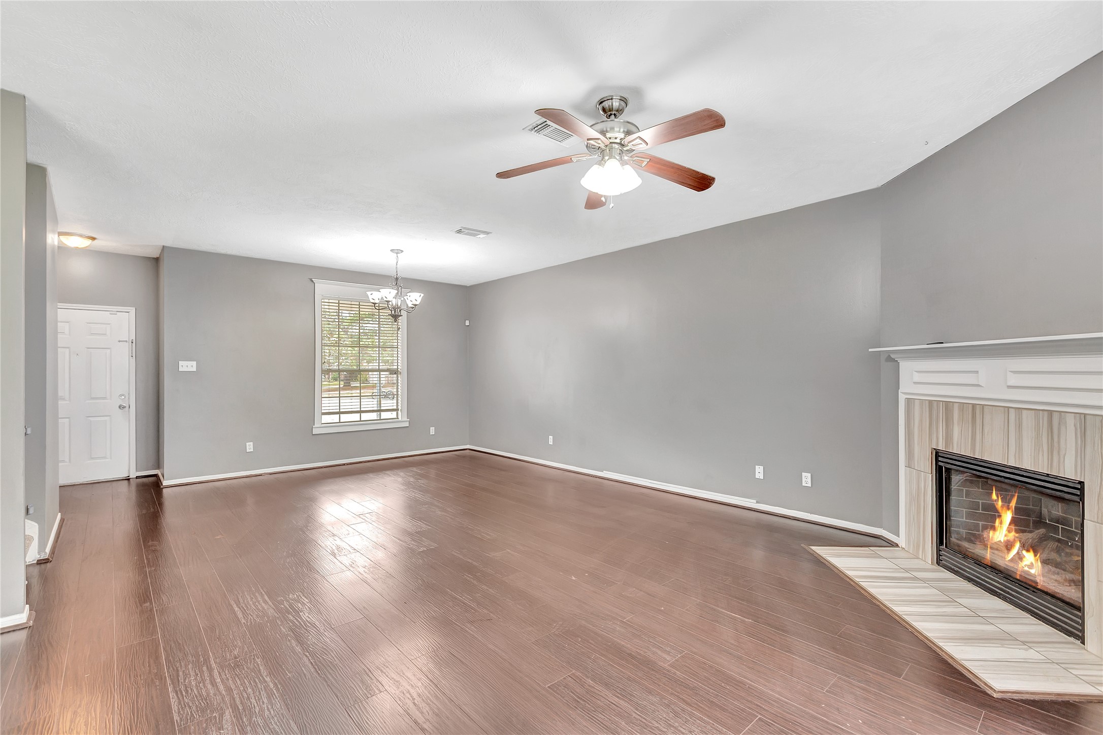 1007 Addison Park Lane Spring, TX 77373 - Photo 6 of 24 This inviting living room seamlessly flows to the front entry, featuring warm hardwood floors and a cozy fireplace, creating a welcoming ambiance for any homebuyer.