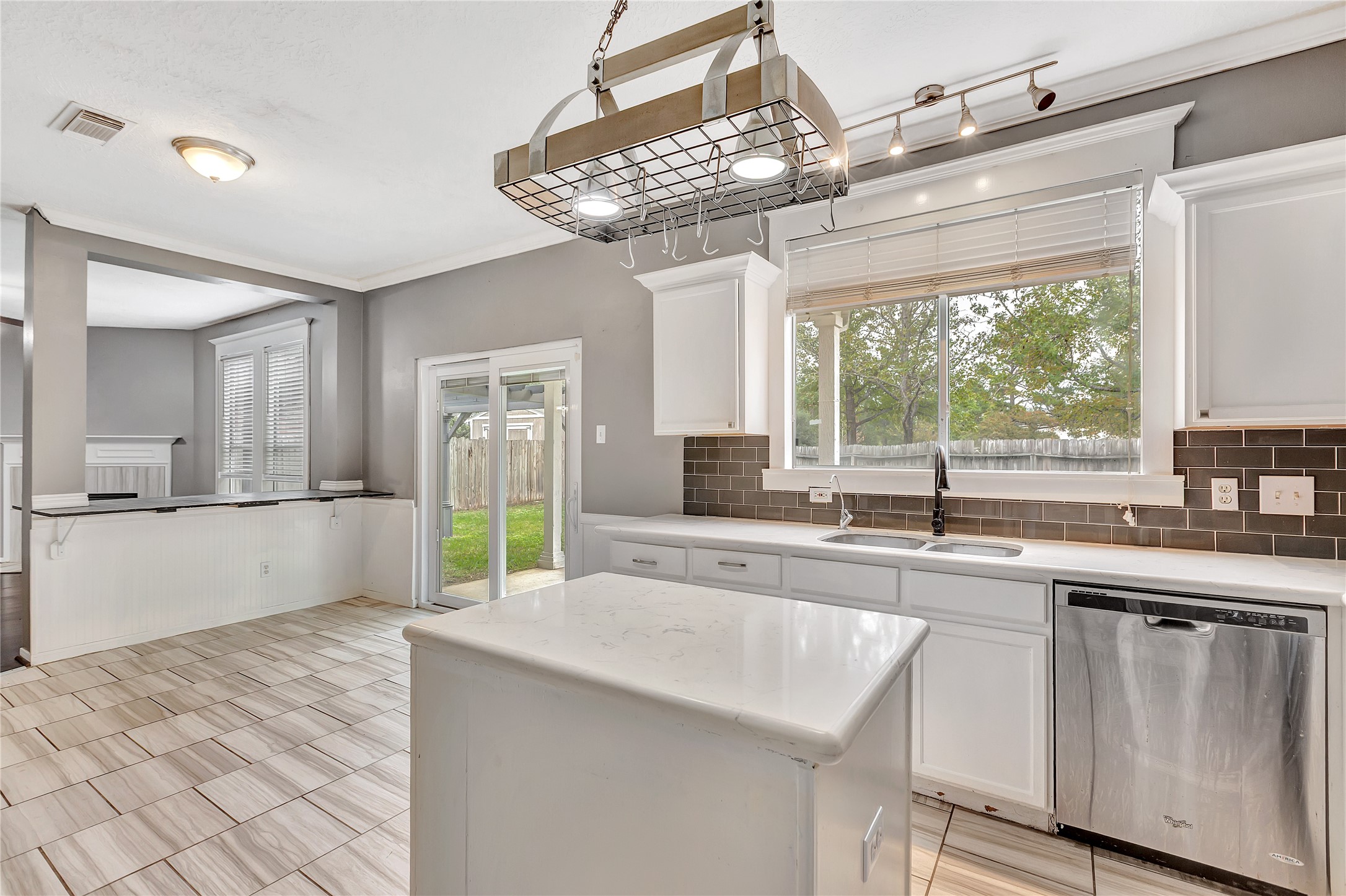 1007 Addison Park Lane Spring, TX 77373 - Photo 8 of 24 This inviting kitchen, easily accessible from the garage, features modern stainless steel appliances, a central island for effortless meal prep, and large windows that flood the space with natural light, creating a perfect blend of functionality and style.