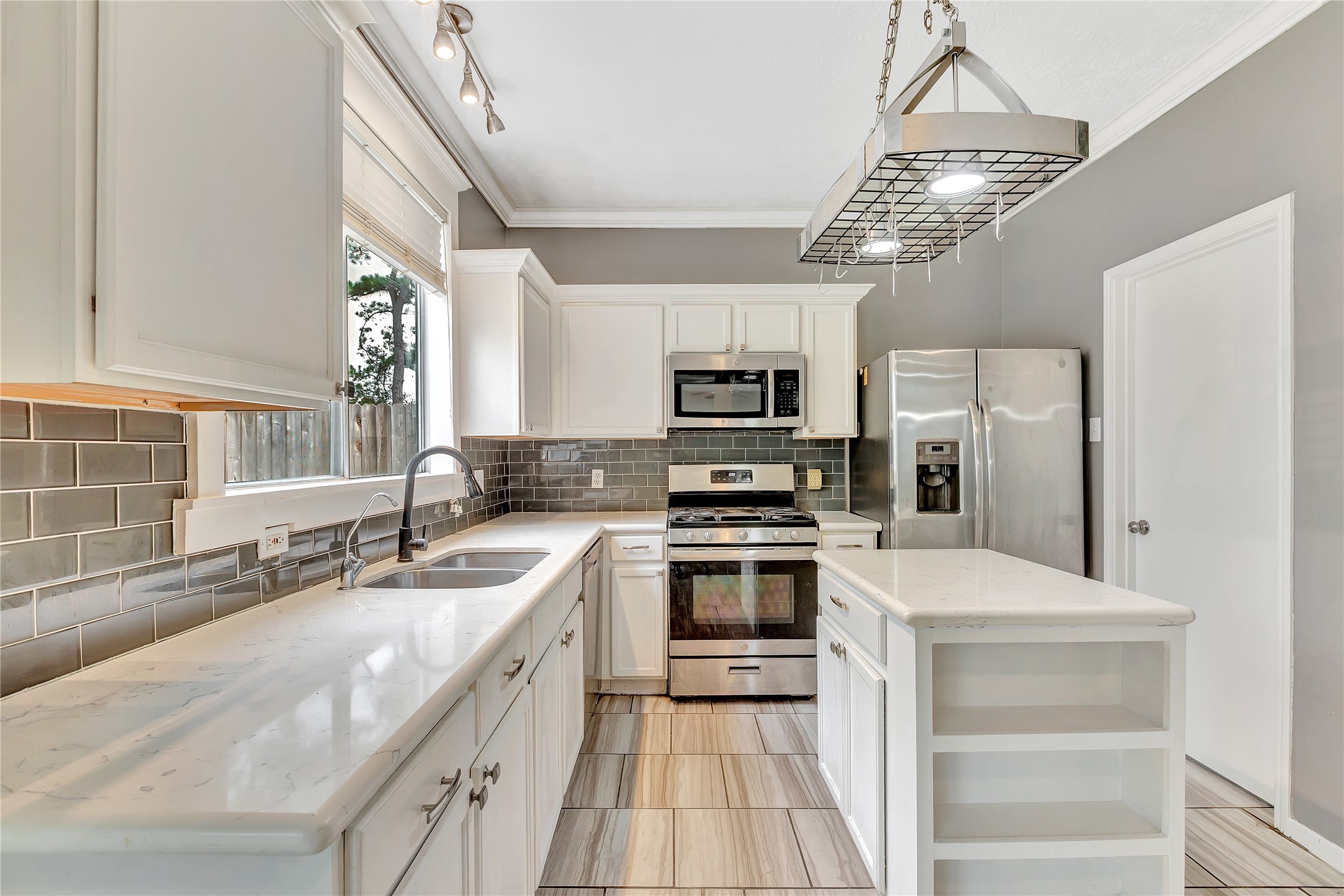 1007 Addison Park Lane Spring, TX 77373 - Photo 9 of 24 Discover culinary bliss in this kitchen, featuring sleek stainless steel appliances, a stylish island, and elegant cabinetry, all bathed in natural light for a warm, inviting atmosphere.