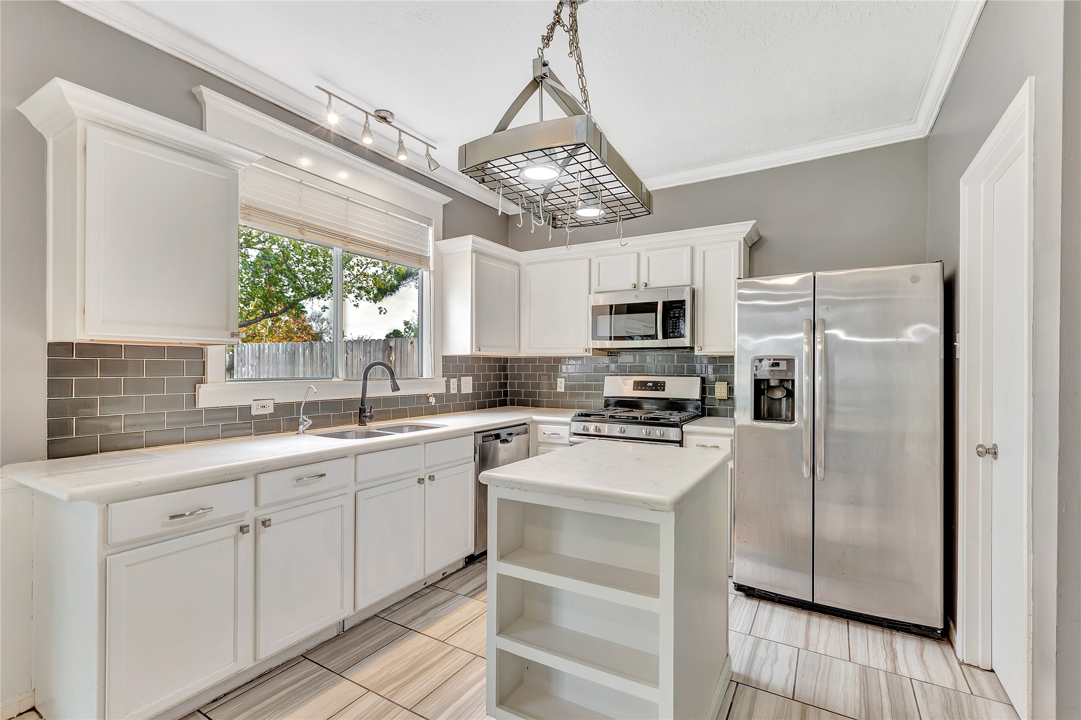 1007 Addison Park Lane Spring, TX 77373 - Photo 10 of 24 This kitchen offers a stylish blend of modern elegance and functionality, featuring sleek stainless steel appliances, pristine white cabinetry, and a chic tile backsplash, perfect for culinary creativity.