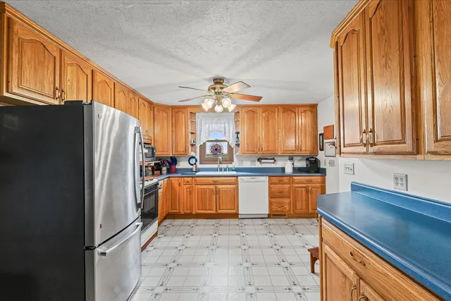 a kitchen with stainless steel appliances a refrigerator sink and cabinets