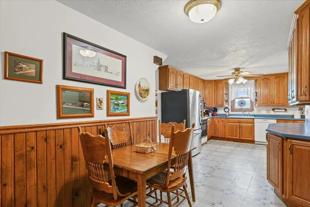 a dining room with stainless steel appliances a refrigerator and a stove top oven