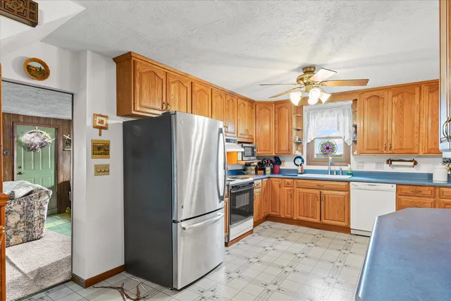 a kitchen with stainless steel appliances granite countertop a refrigerator a stove a sink and a microwave