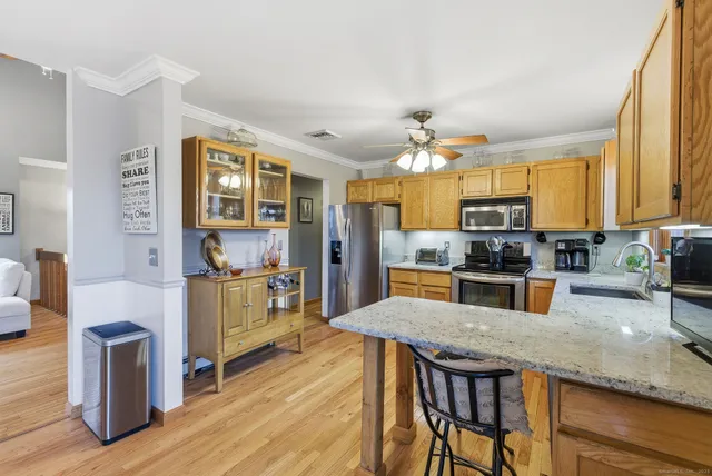 a kitchen with stainless steel appliances granite countertop a stove refrigerator and cabinets