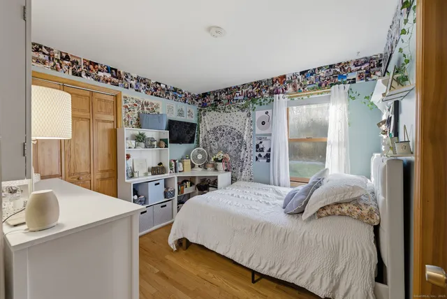 a bedroom with a bed and a large mirror on the dresser