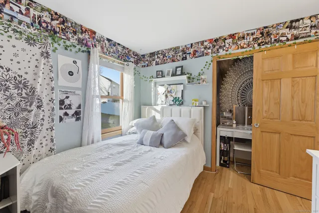 a bedroom with a bed and a large mirror on the dresser