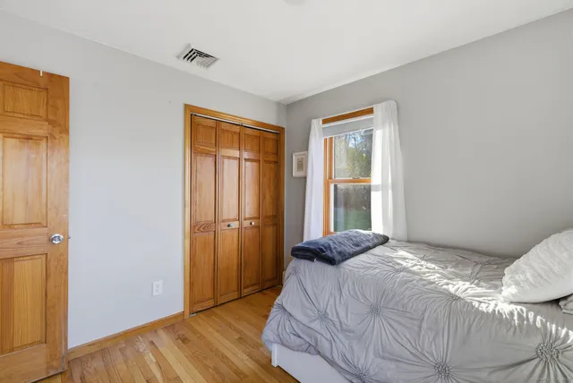 a bedroom with a bed and wooden floor