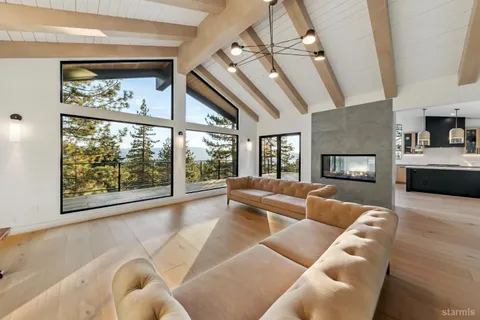 a living room with furniture large window and flat screen tv