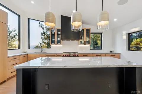 a kitchen with a sink a counter space and a chandelier