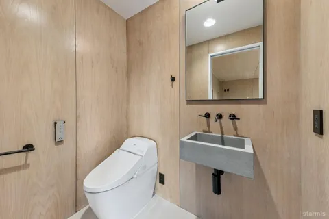 a bathroom with a toilet sink and mirror