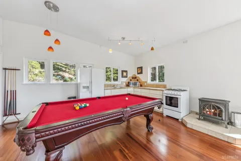 a room with pool table and windows