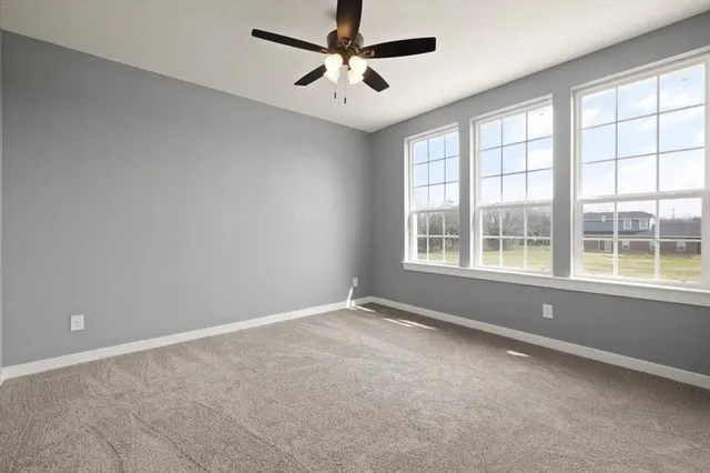 an empty room with closet and windows