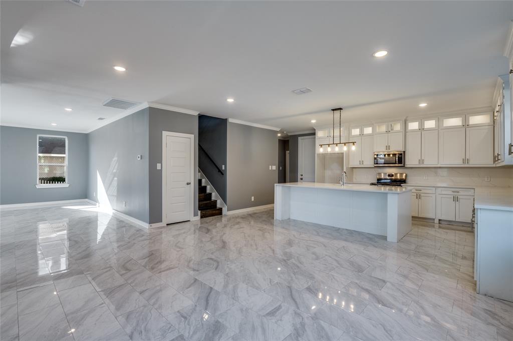 301 South Stewart Avenue Lancaster, TX 75146 - Photo 6 of 35 a view of kitchen with kitchen island white cabinets and refrigerator