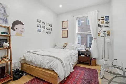 a spacious bedroom with a bed a couch and dresser