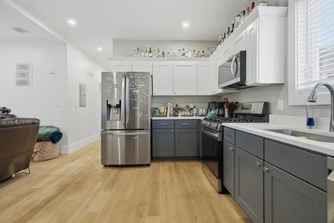 a kitchen with stainless steel appliances granite countertop a refrigerator a stove top oven a sink and dishwasher