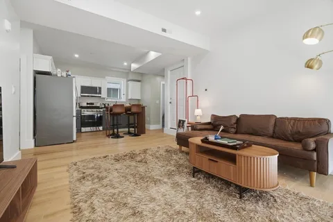 a living room with furniture and kitchen view