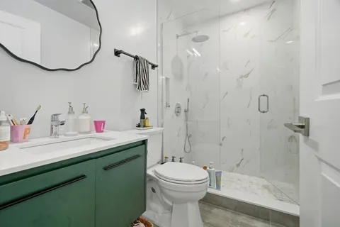 a bathroom with a sink a toilet and shower