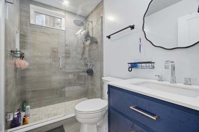 a bathroom with a sink a toilet and shower