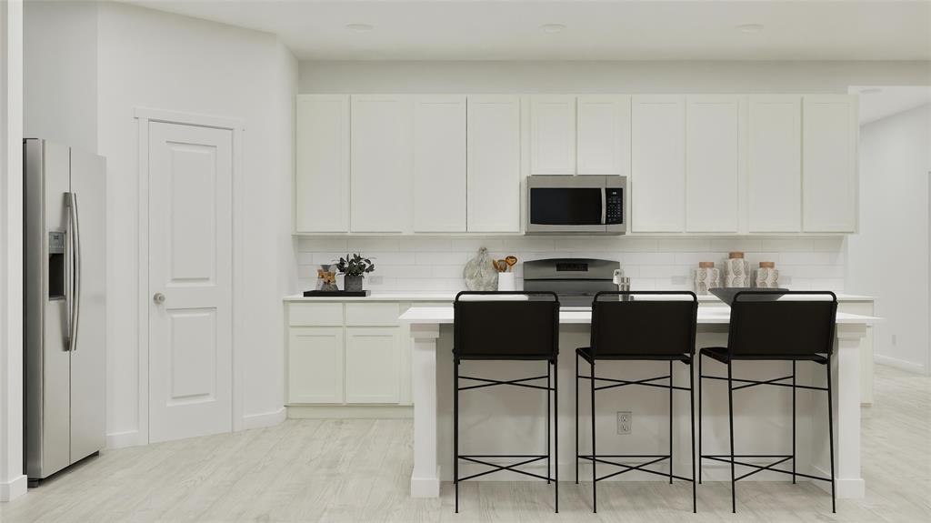1237 Haggetts Pond Road Forney, TX 75126 - Photo 16 of 29 a kitchen with a stove and white cabinets