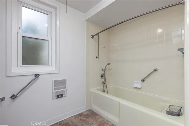 a white bath tub sitting next to a white sink and vanity
