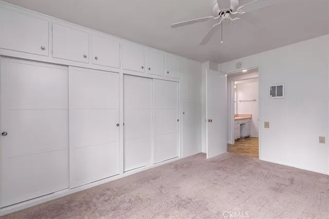a view of an empty room and chandelier fan
