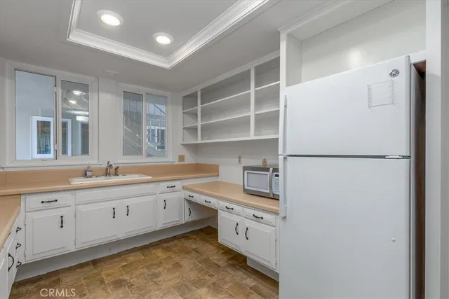 a kitchen with sink refrigerator and cabinets