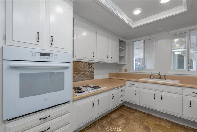 a kitchen with granite countertop white cabinets stainless steel appliances and sink