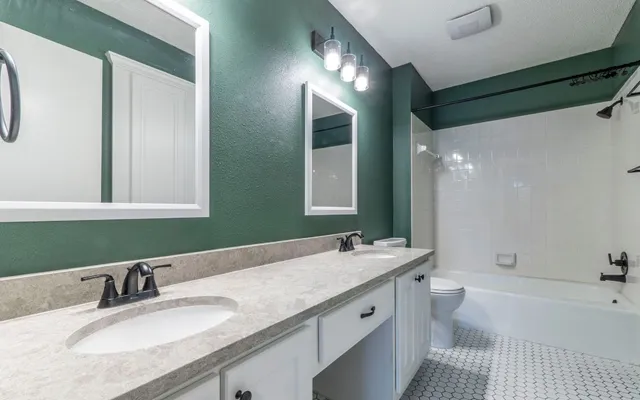 a bathroom with a granite countertop sink mirror and a bathtub
