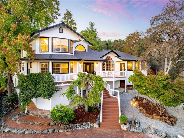 a front view of a residential houses with yard and street