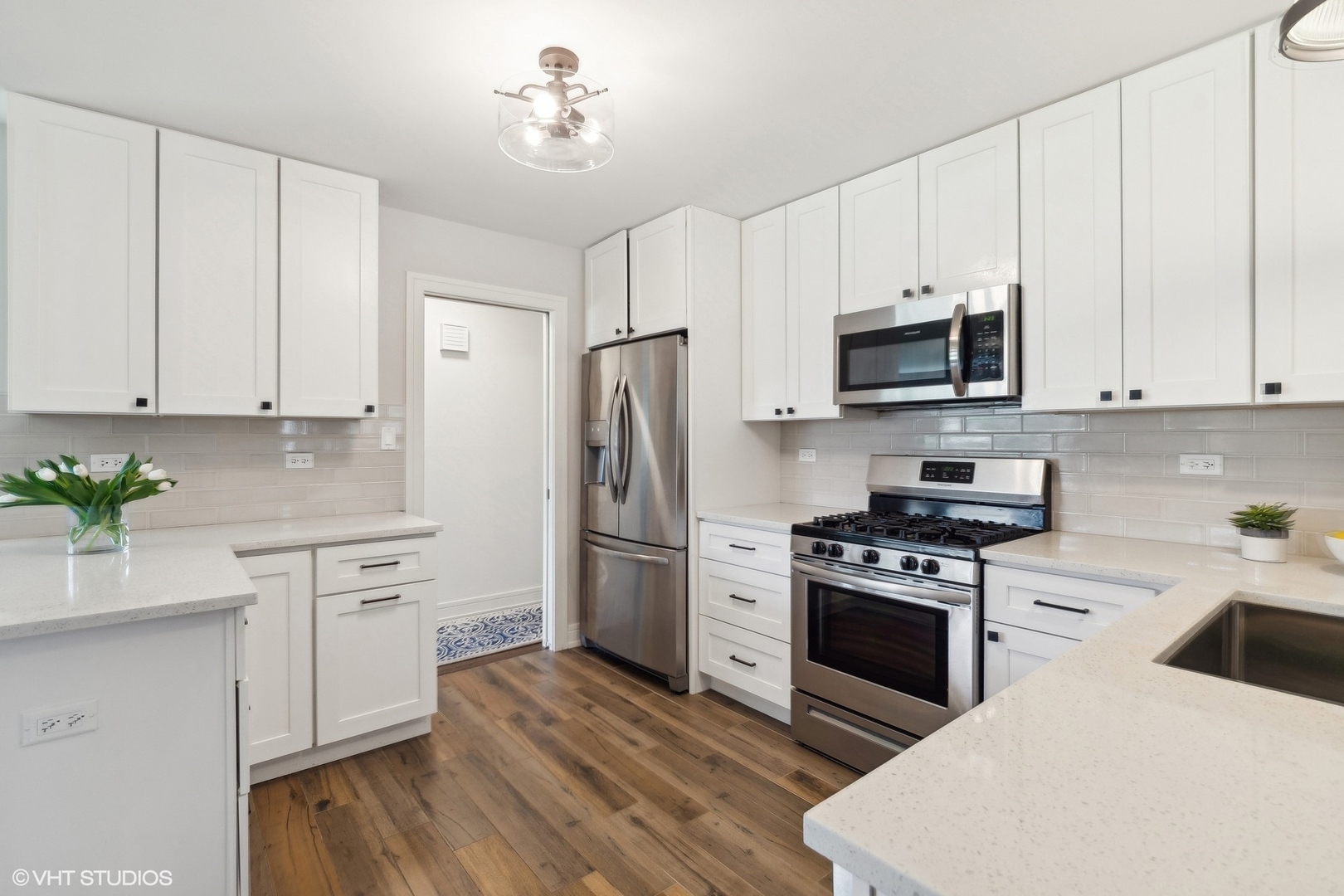 269 Riverside Drive Northfield, IL 60093 - Photo 8 of 28 a kitchen with stainless steel appliances a white cabinets wooden floors and a sink