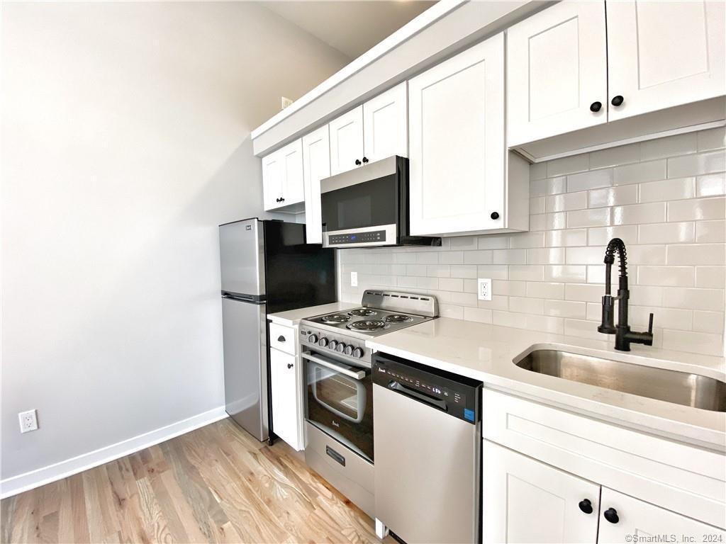 a kitchen with stainless steel appliances granite countertop a sink and a stove