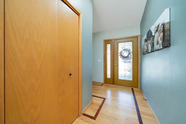 a view of a hallway with wooden floor and windows