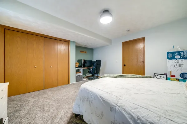 a bedroom with a bed and a large mirror