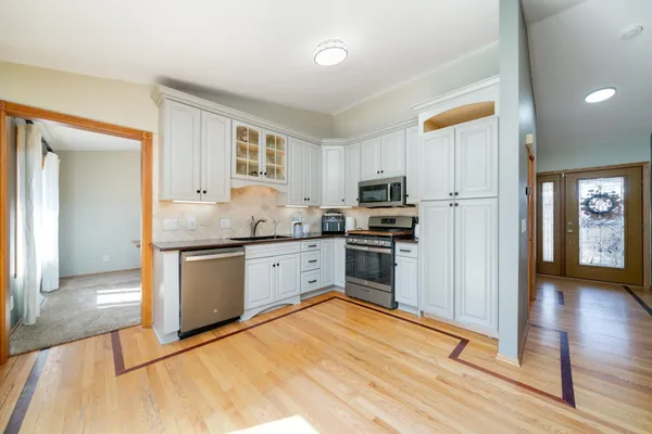 a kitchen with granite countertop a refrigerator stove top oven and sink