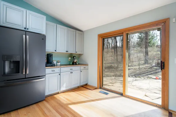 a kitchen with a refrigerator and white cabinets