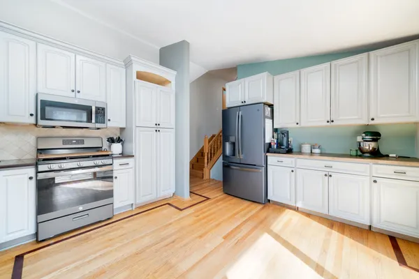 a kitchen with a refrigerator stove and white cabinets