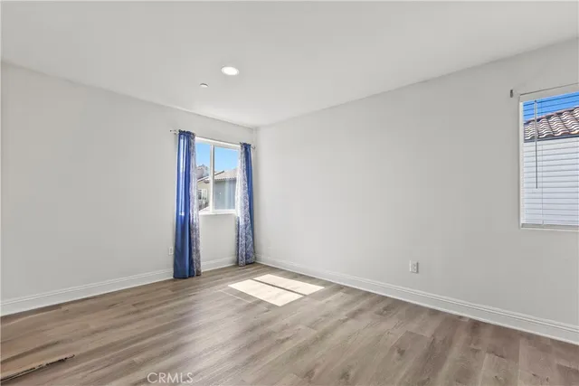 a view of empty room with wooden floor and window