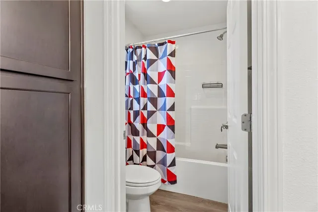 a white toilet sitting next to a shower curtain