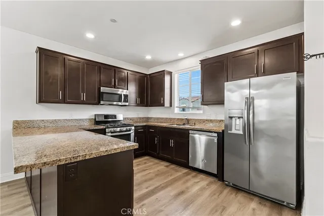a kitchen with granite countertop stainless steel appliances and wooden cabinets