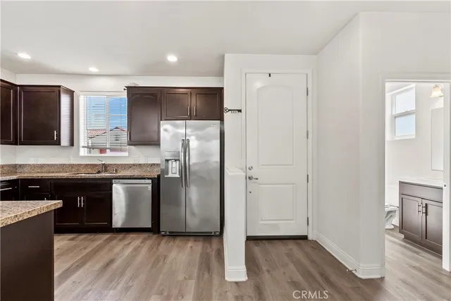 a kitchen with stainless steel appliances granite countertop a refrigerator a sink and a stove