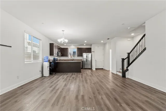 a view of a kitchen with wooden floor and electronic appliances