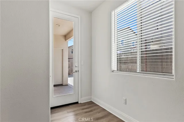 an empty room with a window and wooden floor